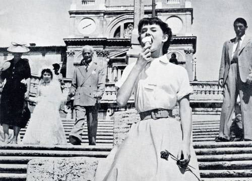 영화 ‘로마의 휴일’에서 여주인공 오드리 헵번이 이탈리아 로마의 스페인광장 앞 계단에서 익살스러운 표정으로 아이스크림을 먹고 있다. 영화 ‘로마의 휴일’ 캡처