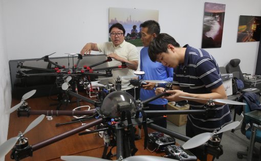 오승환 경성대 사진학과 교수(맨좌)가 드론프레스 직원들과 함께 드론을 점검하고 있다.