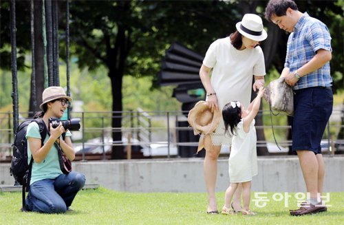 서영희 이룸스냅 대표가 서울 올림픽공원에서 가족 스냅 사진을 촬영하고 있다. 서 씨는 또래의 아이를 키우는 엄마여서 그런지 아이를
 잘 달래가며 사진을 찍었는데 이 점이 피사체들의 자연스러움을 끌어내는 데 많은 역할을 한 것 같았다. 이종승 전문기자 
urisesang@donga.com