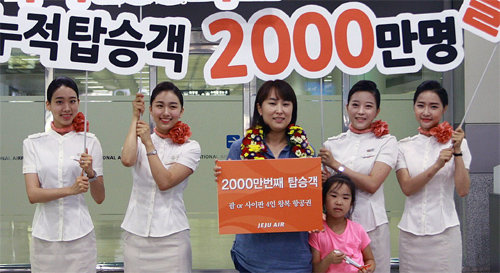 제주항공 2000만 번째 탑승객인 함미향 씨(39·왼쪽에서 세 번째)가 16일 오전 김포국제공항에서 4인 가족 항공권을 받았다. 제주항공 제공