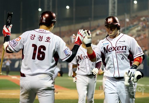 넥센 박병호(오른쪽)가 5일 목동 SK전 5회말 2사 1·2루서 팀에 5-0 리드를 안기는 시즌 34호 좌월 3점홈런을 터트린 뒤 홈에서 홈런왕 경쟁자인 팀 동료 강정호와 하이파이브를 나누고 있다. 목동｜김민성 기자 marineboy@donga.com 트위터 @bluemarine007