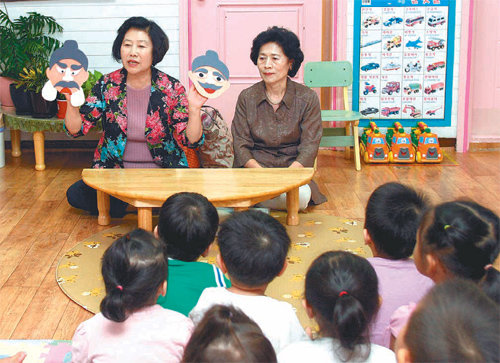 11일 어린이집에서 ‘이야기 할머니’ 김정순 씨(왼쪽)와 박귀조 씨가 직접 만든 천 가면을 들고 어린이들에게 전래동화 ‘혹부리 영감’을 들려주고 있다. 강남구 제공