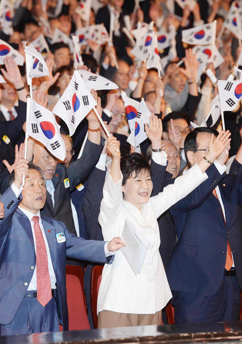 박근혜 대통령이 15일 서울 종로구 세종문화회관에서 열린 제69주년 광복절 경축식에서 참석자들과 함께 태극기를 들고 만세삼창을 하고 있다. 청와대사진기자단