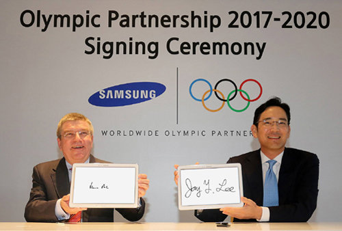 삼성전자가 2020년 올림픽까지 후원하기로 국제올림픽위원회(IOC)와 17일 계약했다. 이재용 삼성전자 부회장(오른쪽)과 토마스 바흐 IOC 위원장이 중국 난징 페어몬트 호텔에서 삼성 태블릿PC에 기념 서명한 뒤 들어 보이고 있다. 삼성전자 제공