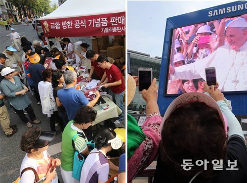 교황 기념품 사고… 휴대전화로 찍고… 프란치스코 교황이 16일 집전한 시복미사를 보기 위해 서울 광화문광장을 찾은 가톨릭 신자와 시민들이 교황 방한 공식 기념품을 사고 있다(왼쪽 사진). 서울광장에 모여 대형 스크린을 통해 시복미사를 본 신자들은 스크린에 나온 교황의 모습을 휴대전화에 담으며 시복미사를 가까이에서 보지 못한 아쉬움을 달랬다. 장승윤 기자 tomato99@donga.com·양회성 기자