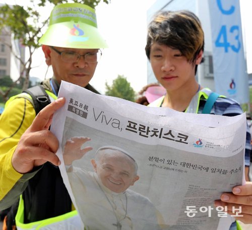 본보 특별판 보는 시민들 교황이 집전한 시복미사에 참석하기 위해 서울 광화문광장을 찾은 가톨릭 신자들이 16일 교황 관련 내용을 다룬 동아일보 특별판을 읽고 있다. 이날 동아일보는 4쪽짜리 특별판 3만 부를 인쇄해 시복미사 현장과 명동성당에 배포했다. 장승윤 기자 tomato99@donga.com