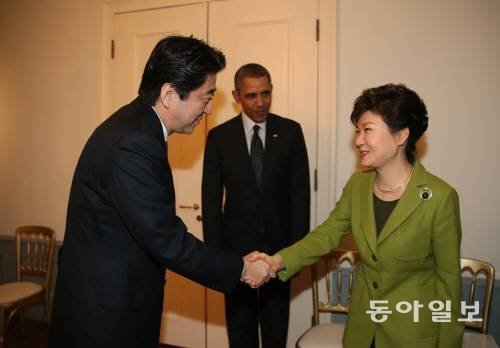 지난 3월 25일 네덜란드 헤이그에 있는 미국대사관저에서  박근혜 대통령(오른쪽)과 아베 신조 일본 총리(왼쪽)가 한미일 정상회담에 앞서 악수를 하고 있다. 가운데는 버락 오바마 미국 대통령. 헤이그=신원건 기자 laputa@donga.com