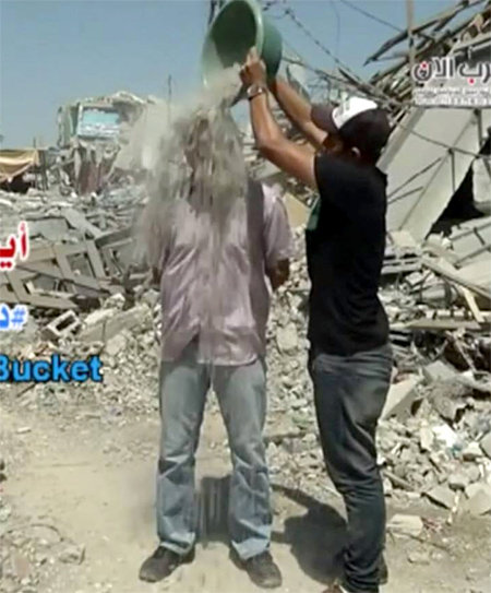 팔레스타인 언론인인 아이만 알알룰 씨(왼쪽)가 동료의 도움을 받아 건물 잔해를 뒤집어쓰고 있다. 러블 버킷 챌린지 동영상 캡처
