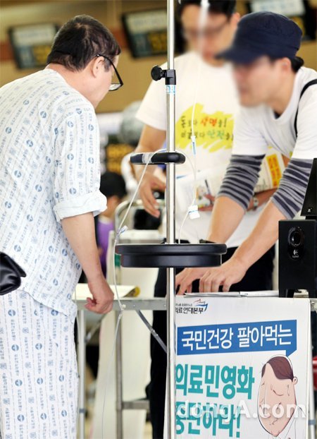 “의료민영화 저지 서명 부탁” 서울 종로구 서울대병원 본원에 입원한 한 환자(왼쪽)가 27일 병원 
로비에서 서울대병원 노조원들로부터 의료민영화 반대 서명운동에 관한 설명을 듣고 있다. 서울대병원 노조는 이날부터 의료민영화 저지를
 앞세우며 무기한 총파업에 들어갔다. 김미옥 기자 salt@donga.com