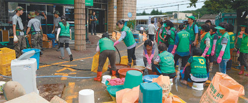 자원봉사자들이 휴일도 잊은 채 31일 비 피해를 입은 부산 기장군 장안읍 좌천리 일대에서 복구작업을 벌이고 있다. 기장군 제공