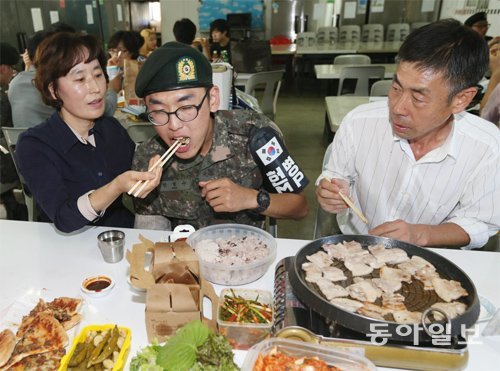 “많이 먹어, 우리 아들” 추석 연휴 첫날인 6일 경기 연천군 육군 25사단 GOP 부대 영내에서 한현수 이병(가운데)의 어머니가 준비한 음식을 아들의 입에 넣어주고 있다. 연천=박영대 기자 sannae@donga.com