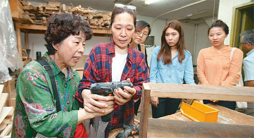 3일 서울 강북구 수유동 ‘재미난 마을’ 내에 있는 공동 작업장인 ‘마을목수공작단’에서 서울 서초구 마을활동가들이 직접 드릴을 들어보며 설명을 듣고 있다. 서초구 제공