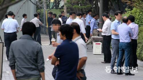 정부가 담뱃값 2000원 인상을 발표한 11일 오후 점심시간 직후 서울 종로구 일대의 직장인들이 삼삼오오 모여 담배를 피우고 있다. 양회성 기자 yohan@donga.com