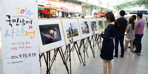 19일까지 인천지하철 인천터미널역에서 열리는 ‘국민참여 사진전’을 찾은 시민들이 사진을 둘러보고 있다. 인천교통공사 제공