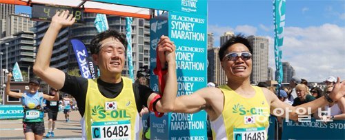 21일 호주 시드니에서 열린 블랙모어스 국제마라톤대회에 참가한 시각장애인 이주상 씨(왼쪽)와 동반주자로 나선 소방관 김남현 씨가 결승선을 통과한 뒤 환호하고 있다. 시드니=이은택 기자 nabi@donga.com