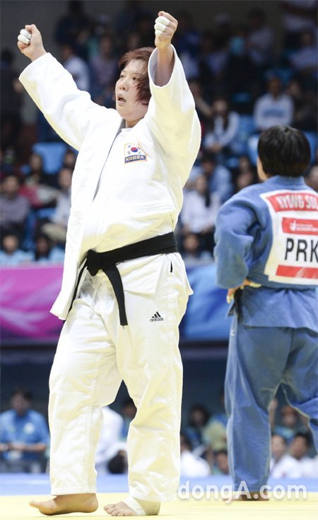 “내가 여왕이다” 한국의 정경미(왼쪽)가 22일 인천 도원체육관에서 열린 유도 여자 78kg급 결승에서 북한의 설경을 지도승으로 누르고 금메달을 확정지은 뒤 두 팔을 번쩍 들어 환호하고 있다. 정경미는 지도 1개를 받아 2개를 받은 설경을 물리쳤다. 인천=원대연 기자 yeon72@donga.com