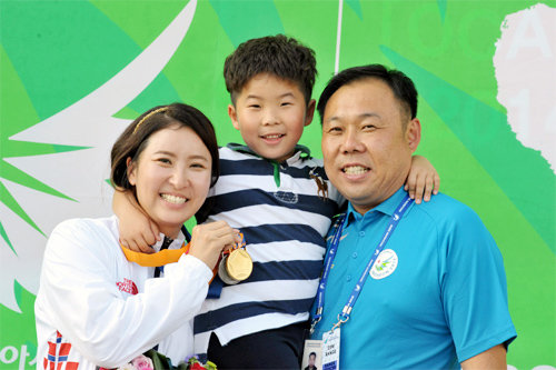 “여보, 수고 많았어” 인천 아시아경기 사격 여자 더블트랩 개인전 금메달을 딴 김미진(왼쪽)이 자신에게 새로운 사격 인생을 열어준 남편 손상원 KB국민은행 감독(오른쪽), 아들 연호 군(6)과 함께 활짝 웃고 있다. 대한사격경기연맹 제공