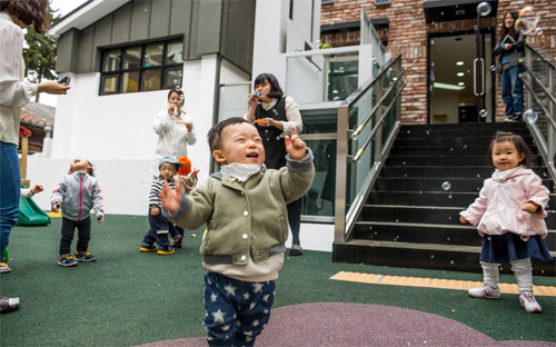 롯데푸드가 서울 영등포구 양평로21길 본사 인근에 마련한 ‘아이사랑 어린이집’ 놀이터에서 아이들이 비눗방울 놀이를 하며 환하게 웃고 있다. 롯데푸드 제공