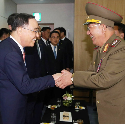 정홍원 국무총리(왼쪽)가 4일 인천 아시아드 주경기장에서 황병서 북한 인민군 총정치국장과 밝은 표정으로 악수하고 있다.