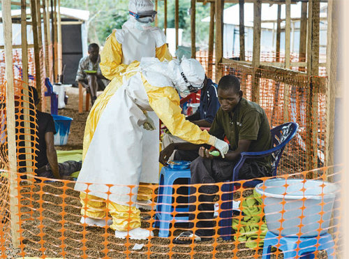 라이베리아에 있는 에볼라 치료센터에서 '국경 없는 의사회'소속 의료진들이 방역복으로 중무장한 채 주민들의 상태를 살피고 있다. 국경없는 의사회 제공