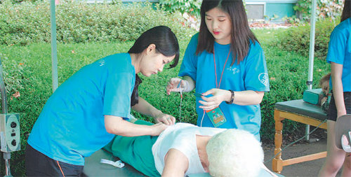 지난달 26일 가천대 메디컬캠퍼스 물리치료과 여학생들이 의료봉사 캠프를 찾은 한 노인에게 전기 치료를 하고 있다. 이 대학 의료 관련 8개 학과 학생들은 다음 달 2차 봉사활동에 나선다. 가천대 제공