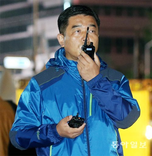 류성호 서울 종로경찰서 경비과장이 18일 서울 광화문광장에서 열린 집회 상황을 보며 무전기로 지시하고 있다. 최혁중 기자 sajinman@donga.com