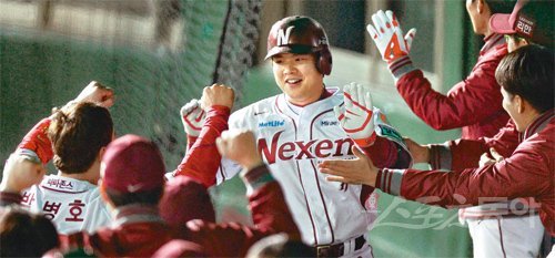 홈런왕도 “축하해” 넥센 윤석민(가운데)이 27일 목동구장에서 열린 LG와의 프로야구 플레이오프 1차전에서 2-3으로 뒤진 6회말 1사 2, 3루에서 오른쪽 담장을 넘기는 3점 홈런을 친 뒤 동료들의 축하를 받고 있다. 김민성 스포츠동아 기자 marineboy@donga.com