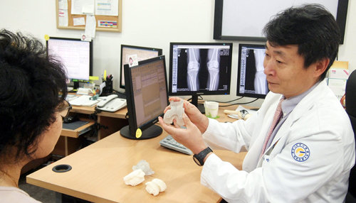김용찬 연세사랑병원 원장이 환자에게 맞춤형 인공관절 수술 도구를 설명하고 있다.