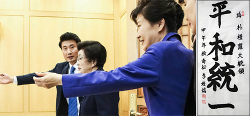박근혜 대통령(오른쪽)이 28일 청와대에서 이희호 여사(가운데)를 접견하기 전 자리를 안내하고 있다. 오른쪽은 이 여사가 박 대통령에게 선물한 휘호. 청와대사진기자단