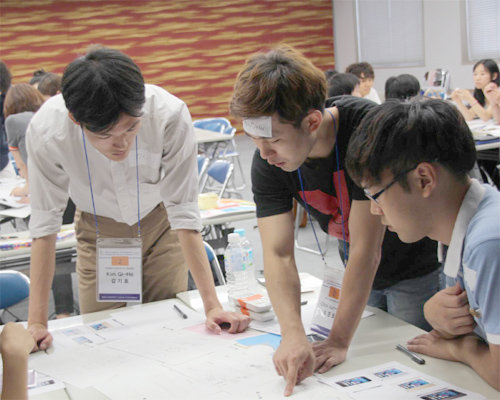 2014년 8월 일본 고베에서 열린 ‘인덕대 창의융합 글로벌 세미나’에 참석한 인덕대 학생들이 직접 제출한 디자인 아이디어를 가지고 활발하게 토론하고 있다. 인덕대 제공