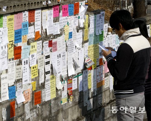 한 시민이 벽에 붙은 전월세 전단을 꼼꼼히 살피고 있다. 동아일보DB