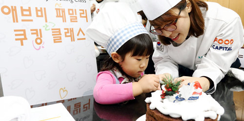 자녀와 함께 ‘패밀리 쿠킹 클래스’에 참가한 한국애브비의 한 직원이 케이크를 만들며 즐거워하고 있다. 한국애브비 제공