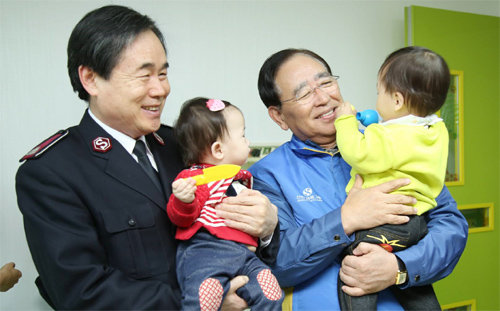 한동우 신한금융지주 회장(오른쪽)이 9일 서울후생원에서 연말 자원봉사 활동을 하며 아이들을 돌보고 있다. 신한금융지주 제공