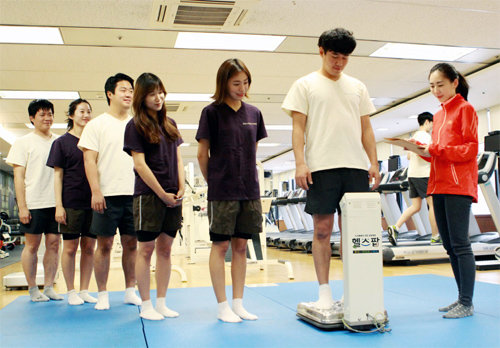 임직원 건강 증진과 기부를 동시에 실천하는 ‘건강&나눔 프로젝트 헬스팝’ 캠페인을 통해 체중 감량에 도전한 삼성디스플레이 직원들이 8일 사내 피트니스센터에서 체중을 측정하고 있다. 삼성디스플레이 제공