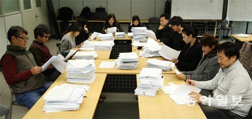 2015년 동아일보 신춘문예 예심에서 작품을 검토하고 있는 심사위원들. 올해는 사회적 관심보다 개인적 아픔을 다룬 작품이 많았다. 왼쪽부터 조철현 이기호 김숨 김미월 편혜영 정이현 박성원 백가흠 김민정 김경주 정윤수 씨. 신원건 기자 laputa@donga.com