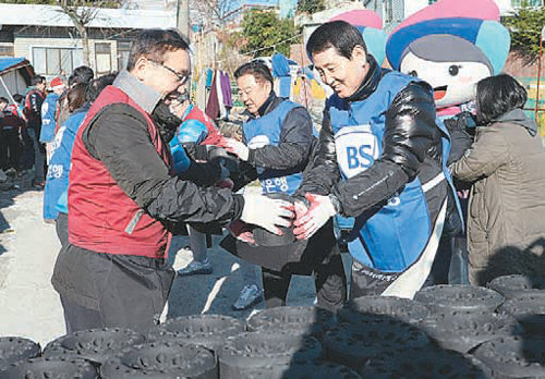 성세환 BS금융그룹 회장(오른쪽)과 강명구 신세계 사이먼 대표가 최근 부산 기장군 기장읍에서 사랑의 연탄 배달 봉사활동을 펼쳤다. 부산은행 제공