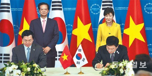 한-아세안 특별정상회의 참석을 위해 부산을 방문한 응우옌떤중 베트남 총리(뒤 왼쪽)와 박근혜 대통령이 지켜보는 가운데 한-베트남 
자유무역협정(FTA) 서명식이 진행되고 있다. 이날 FTA 체결은 현 정부 들어 호주, 캐나다, 중국, 뉴질랜드에 이어 다섯 
번째다. 부산=신원건 기자 laputa@donga.com