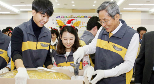 11일 서울 영등포구 여의도동 국민은행 본점에서 윤종규 KB금융 회장 겸 국민은행장(오른쪽)과 KB금융의 CF 모델인 가수 이승기 씨(왼쪽)가 홀몸노인을 위한 겨울용품을 포장하고 있다. KB금융 제공