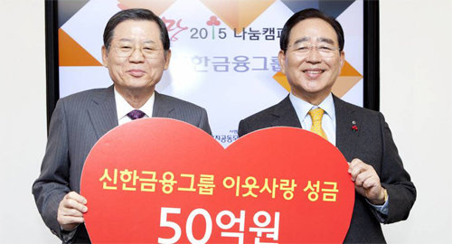 15일 서울 중구 사회복지공동모금회 본사에서 한동우 신한금융지주 회장(오른쪽)이 허동수 사회복지공동모금회장에게 연말 이웃사랑 성금 50억 원을 전달하고 있다. 신한금융지주 제공