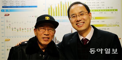 경비원과 상생을 이뤄낸 아파트로 꼽히는 서울 성북구 석관동 두산아파트의 김재규 경비원(왼쪽)과 심재철 입주자대표가 16일 함께 웃고 있다. 올 10월 입주자대표회의는 경비비 대신 전기료를 줄이는 등의 아이디어로 경비원의 내년 최저임금을 100% 보장하기로 했다. 최혁중 기자 sajinman@donga.com