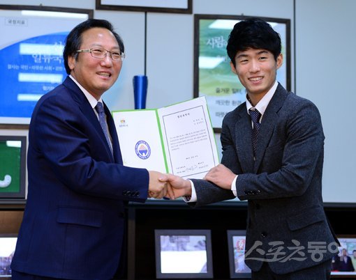 남자체조의 간판스타 양학선(오른쪽)이 수원시청에 입단해 안정적으로 운동할 수 있는 기반을 확보했다. 양학선이 17일 수원시체육회관에서 열린 입단식에서 이내응 수원시체육회 사무국장과 악수하고 있다. 수원｜김민성 기자 marineboy@donga.com 트위터 @bluemarine007