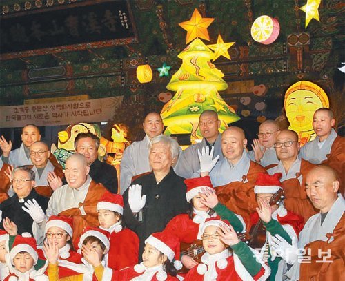 조계사 앞 성탄트리 17일 오후 서울 조계사 일주문 앞에 설치된 크리스마스트리에 불이 들어오자 종교계 인사들과 조계사 어린이합창단원들이 손을 들어 환호하고 있다. 신원건 기자 laputa@donga.com