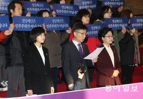 18일 오전 서울 여의도 국회 본관 1층 로비에서 통합진보당 의원과 보좌관들이 ‘통합진보당 강제해산 저지 민주수호’를 주장하며 기자회견을 열고 있다. 헌법재판소는 19일 통합진보당에 대한 정당 해산 여부를 최종 결정한다. 변영욱 기자 cut@donga.com