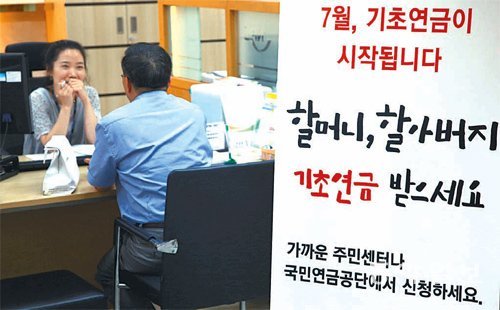 논란 속 시행은 했지만… 기초연금 접수가 시작된 7월 1일 한 노인이 주민센터에서 상담을 받고 있다. 
기초연금은 전문가들로부터 ‘노인 생활고를 덜어주면서도 장기 재정 안정까지 도모했다’는 비교적 후한 점수를 받은 반면 일반 
국민들로부터는 ‘반쪽짜리 연금’이라는 박한 평가를 받았다. 동아일보DB