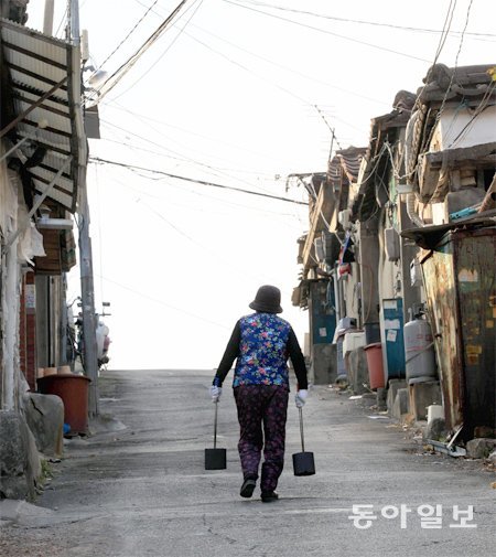 연탄을 든 한 여인이 골목길을 오르고 있다. 빈곤 문제를 해결하기 위해서는 복지제도를 촘촘하게 보완할 필요가 있다. 동아일보DB