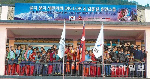 세계적인 산악인 엄홍길 대장(가운데)이 지난해 12월 27일 네팔 골리에서 휴먼스쿨 준공식에 참석해 학생들과 기념 촬영을 하고 있다. 엄홍길휴먼재단 제공