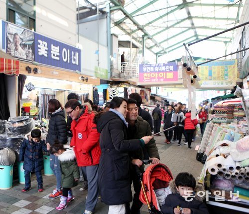 부산 중구 국제시장을 찾은 시민들이 영화 ‘국제시장’의 배경이 된 ‘꽃분이네’ 가게 앞에서 기념사진을 찍고 있다. 이 가게는 원래 ‘영신상회’란 간판을 달고 운영됐지만 관광객이 몰리면서 지난해 12월 24일 이름을 바꿨다. 강성명 기자 smkang@donga.com