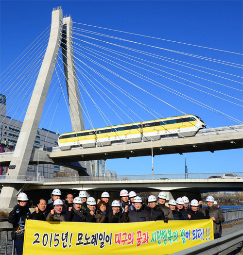 대구도시철도건설본부 직원들이 대구 수성구 신천교량에서 모노레일을 배경으로 안전한 시운전과 무사고 결의를 다지고 있다. 대구도시철도건설본부 제공