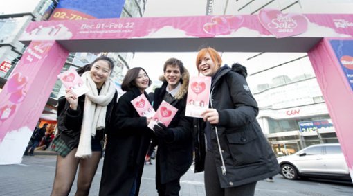 ‘2015 코리아그랜드 세일’의 이벤트부스가 있는 명동에서 행사 브로슈어를 들고 웃고 있는 외국인 관광객들. 이벤트부스는 9일 스페셜 테마위크가 시작되면 동대문으로 위치를 옮겨 이벤트를 진행한다. 사진제공｜한국방문위원회