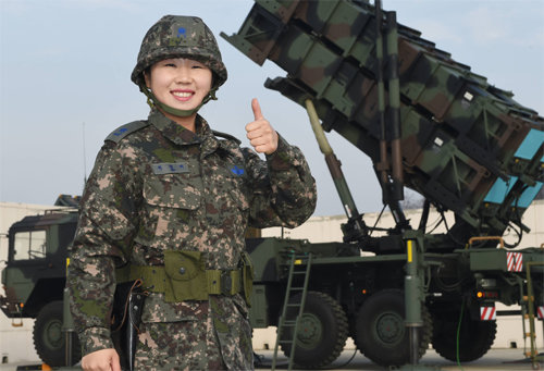 공군 사상 최초의 여성 방공 미사일 포대장인 이영미 소령이 6일 충북 청주에 있는 자신의 부대에 배치된 패트리엇 미사일 앞에서 밝게 웃고 있다. 공군 제공